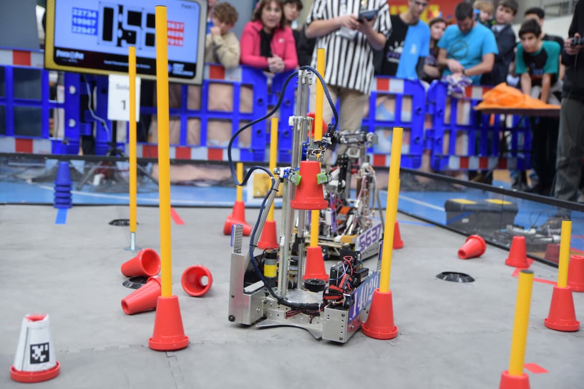 תמונה של רובוט FIRST Tech Challenge מרים קונוסים בתוך מסלול מאתגר.